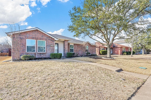 ranch-style home with a front yard and brick siding