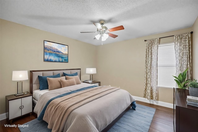 bedroom with a ceiling fan, baseboards, dark wood finished floors, and a textured ceiling