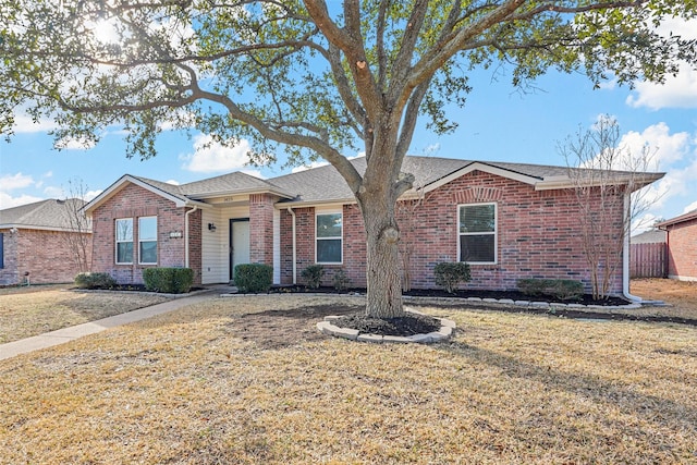 single story home featuring a front yard and brick siding