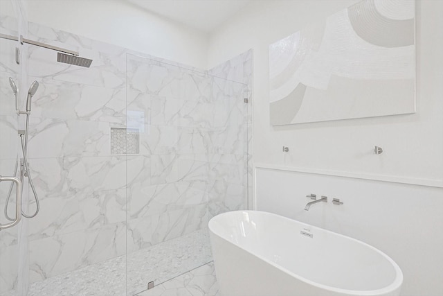 bathroom with a freestanding tub and a marble finish shower