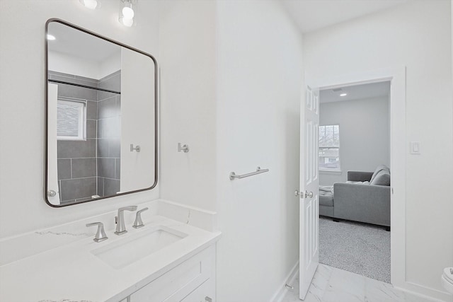 ensuite bathroom with ensuite bathroom, marble finish floor, vanity, and baseboards