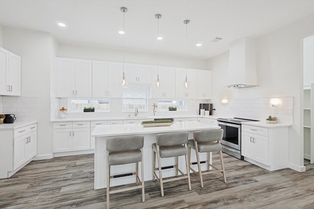 kitchen with white cabinets, stainless steel range with electric stovetop, and light countertops