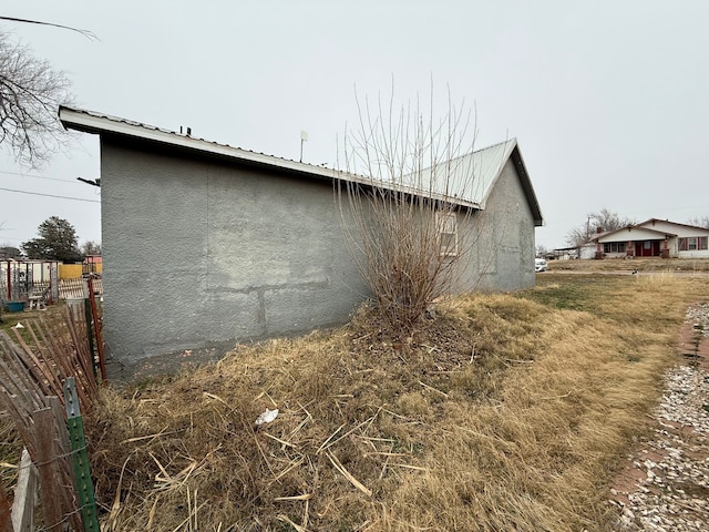 view of property exterior featuring fence and stucco siding