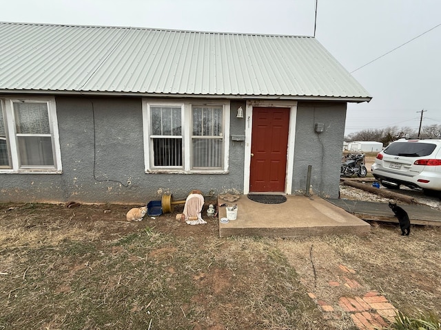 view of front of property featuring metal roof and stucco siding