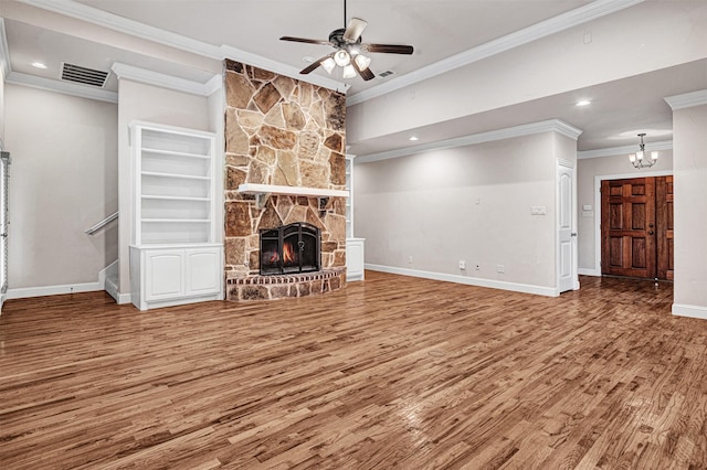 unfurnished living room with a fireplace, visible vents, wood finished floors, baseboards, and ceiling fan with notable chandelier