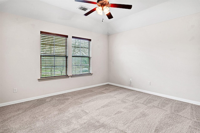 spare room featuring ceiling fan, carpet flooring, visible vents, baseboards, and vaulted ceiling