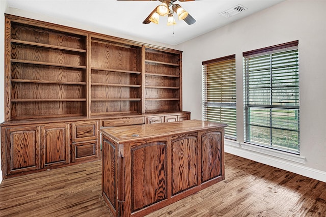 office space featuring baseboards, light wood-style flooring, visible vents, and a ceiling fan