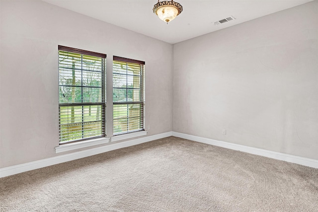 spare room with carpet, visible vents, and baseboards