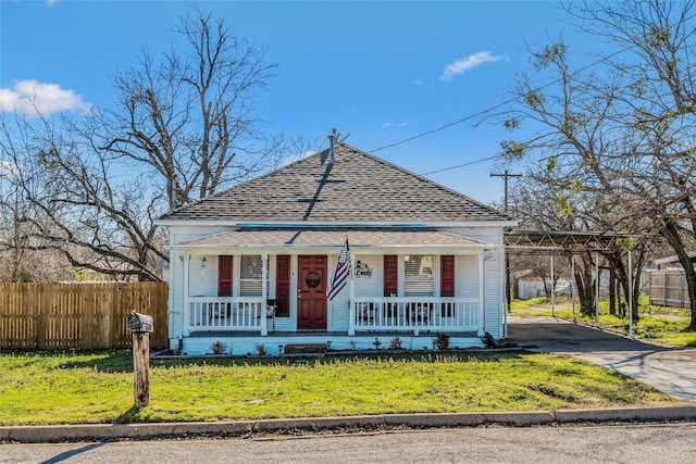 view of front facade with a carport, a porch, a front lawn, and driveway