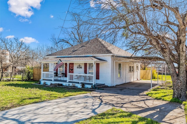 view of front of house with a porch, aphalt driveway, roof with shingles, a carport, and a front lawn