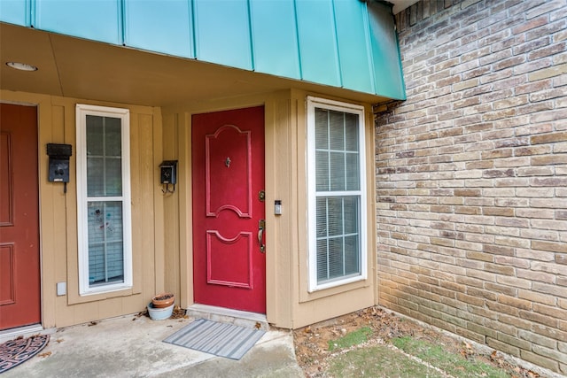 entrance to property featuring brick siding