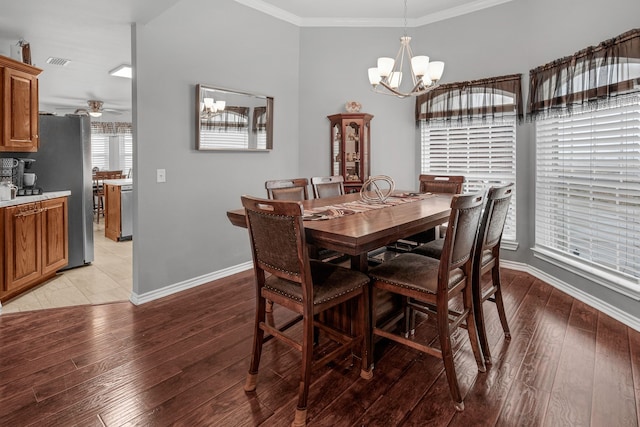 dining area with light wood-style floors, visible vents, ornamental molding, and baseboards