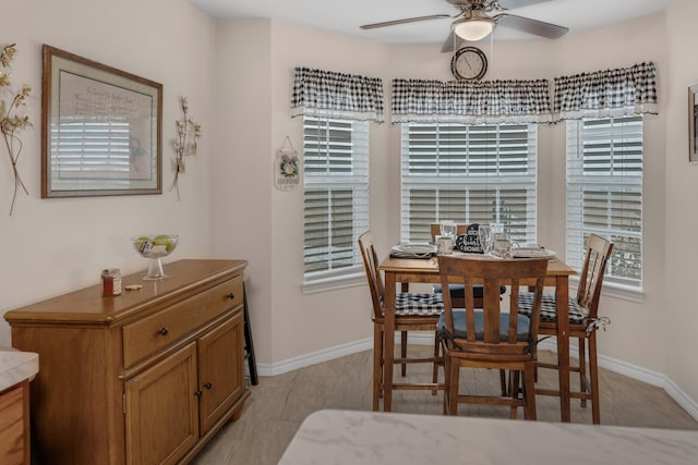 dining room featuring a ceiling fan and baseboards