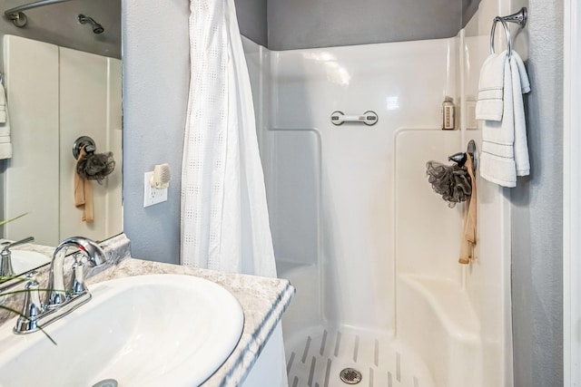 full bath with a shower stall and vanity