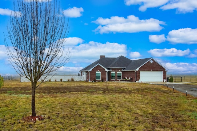 ranch-style house featuring driveway, a chimney, an attached garage, a front yard, and brick siding