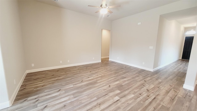 empty room with light wood finished floors, baseboards, and a ceiling fan