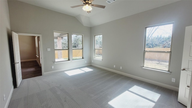 unfurnished room with lofted ceiling, light colored carpet, a ceiling fan, baseboards, and visible vents