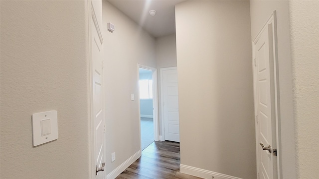 hall with baseboards and wood finished floors