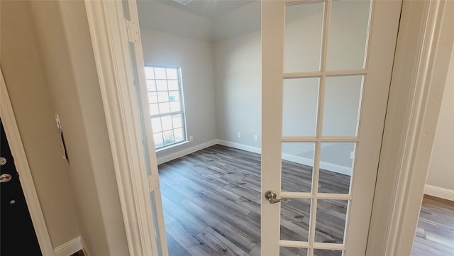 unfurnished room with light wood-style floors, french doors, and baseboards