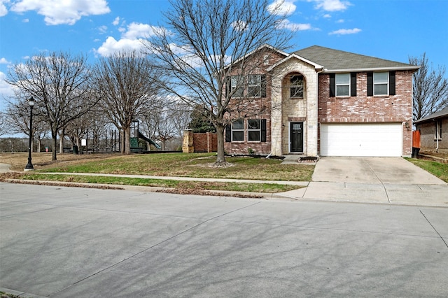 view of front of home with driveway, a garage, roof with shingles, a front lawn, and brick siding