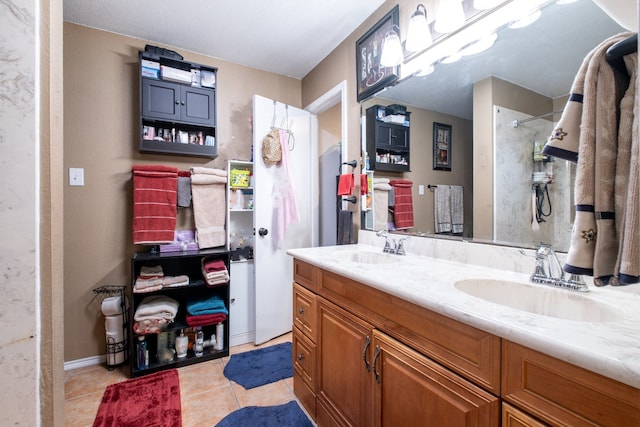 bathroom featuring double vanity, a shower, a sink, and tile patterned floors