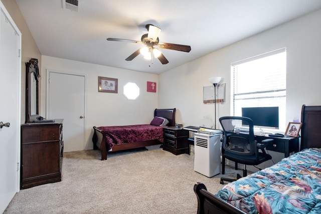 bedroom featuring light colored carpet, visible vents, ceiling fan, and multiple windows