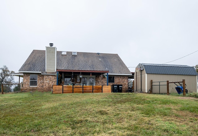 rear view of house featuring brick siding, a shingled roof, a chimney, and a yard