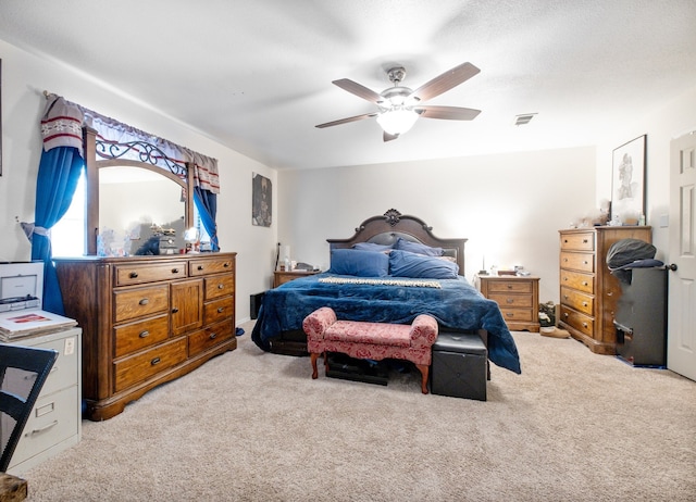 bedroom with light colored carpet, ceiling fan, and visible vents