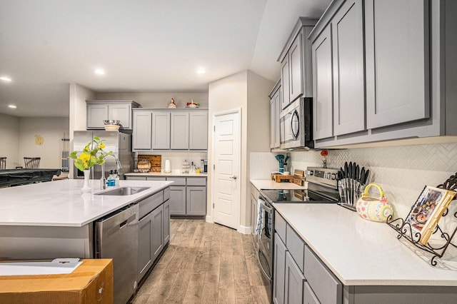 kitchen with appliances with stainless steel finishes, light countertops, light wood-style floors, and gray cabinetry