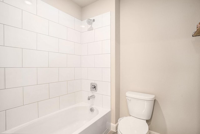 bathroom with toilet, baseboards, and shower / bathtub combination