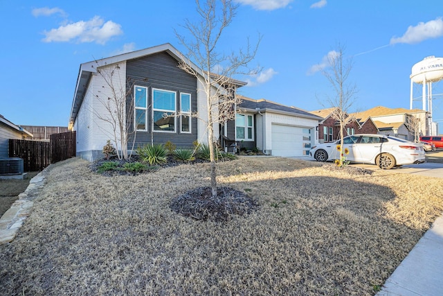 ranch-style house with a garage, driveway, fence, and central air condition unit