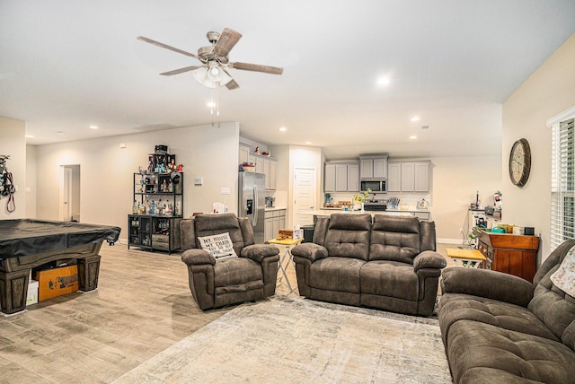 living room with a bar, light wood-style flooring, ceiling fan, and recessed lighting