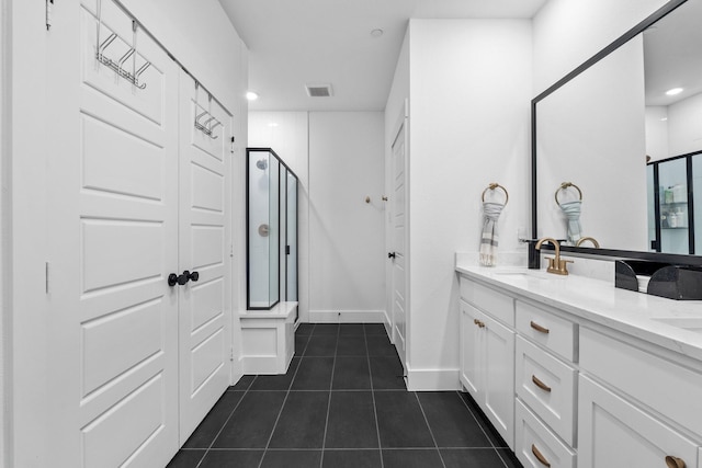 bathroom with double vanity, visible vents, a sink, a shower stall, and tile patterned flooring