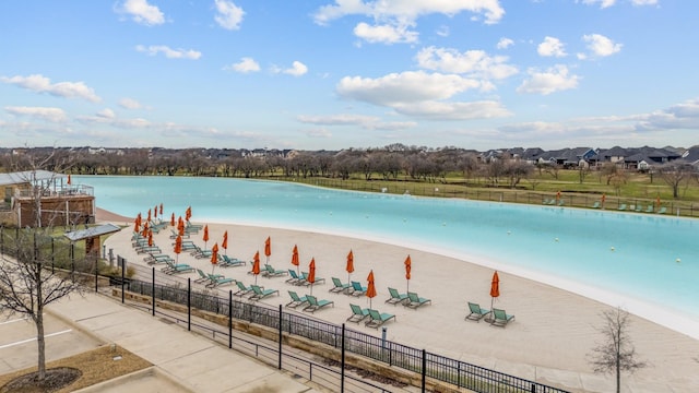 view of water feature featuring fence and a beach view