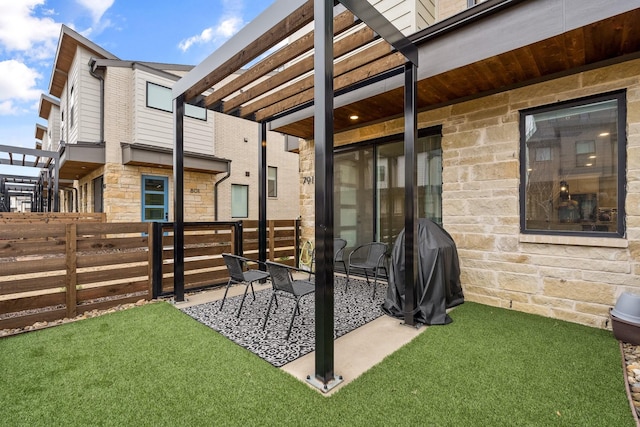 view of patio with area for grilling, fence, and a pergola