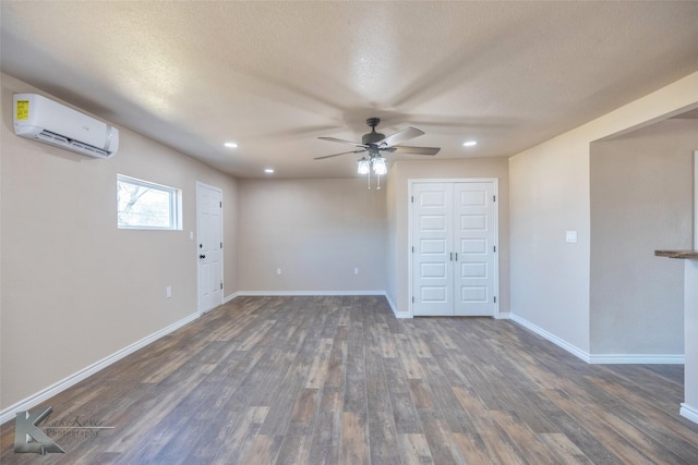 empty room with recessed lighting, a wall mounted AC, dark wood-type flooring, a ceiling fan, and baseboards