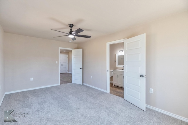 unfurnished bedroom with ceiling fan, baseboards, carpet flooring, and ensuite bathroom