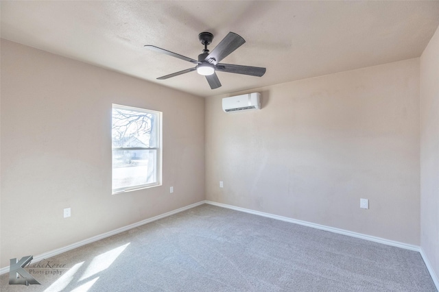 carpeted empty room featuring an AC wall unit, a ceiling fan, and baseboards