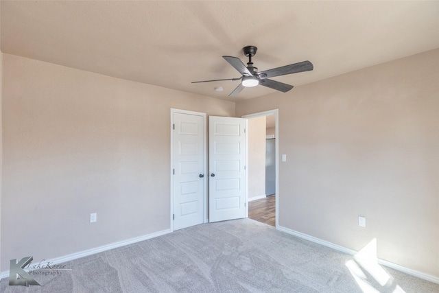 unfurnished bedroom with carpet floors, a ceiling fan, and baseboards