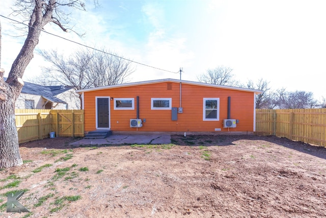 back of property with entry steps and a fenced backyard