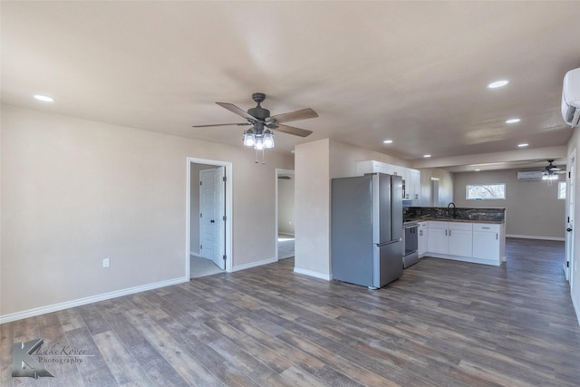 kitchen featuring stainless steel appliances, dark countertops, open floor plan, and white cabinets