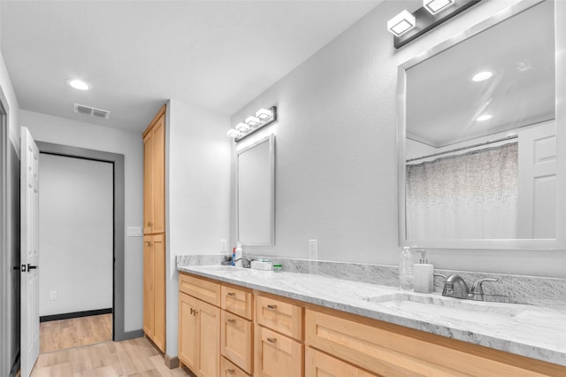 full bathroom with recessed lighting, wood finished floors, a sink, visible vents, and double vanity