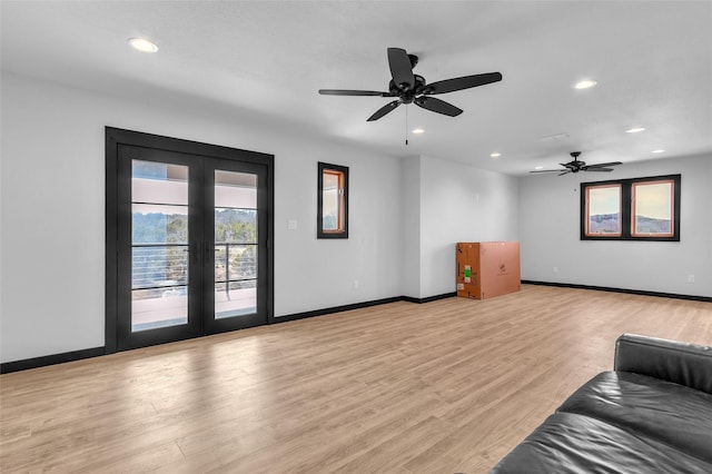 living room with recessed lighting, light wood-style flooring, and french doors