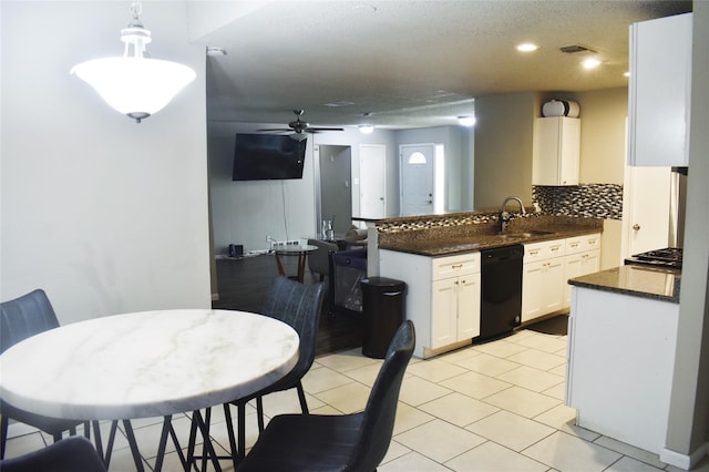 kitchen featuring dark countertops, black dishwasher, white cabinetry, and decorative light fixtures