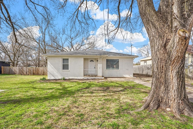 view of front of home featuring brick siding, a front yard, and fence