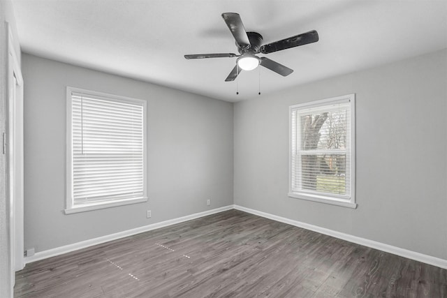 unfurnished room with baseboards, wood finished floors, and a ceiling fan