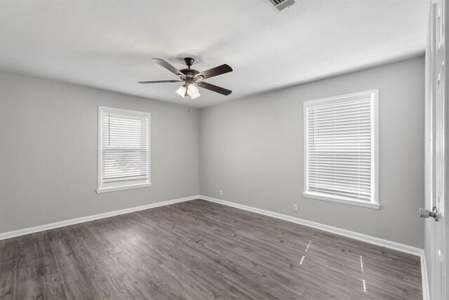 empty room with baseboards, dark wood-style flooring, and ceiling fan