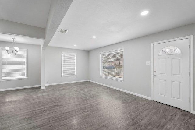 entryway featuring an inviting chandelier, dark wood-type flooring, baseboards, and visible vents