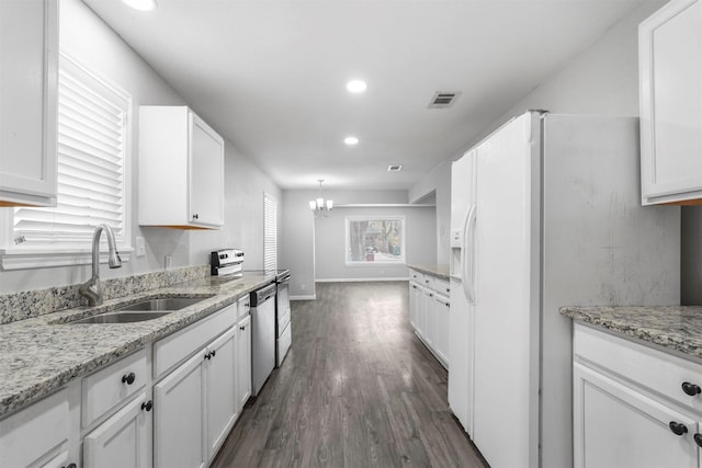 kitchen featuring white cabinetry, dishwasher, white refrigerator with ice dispenser, and a sink