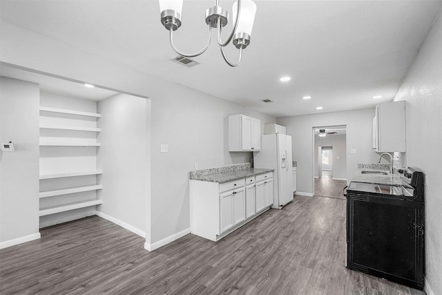 kitchen with wood finished floors, baseboards, a sink, white refrigerator with ice dispenser, and white cabinetry